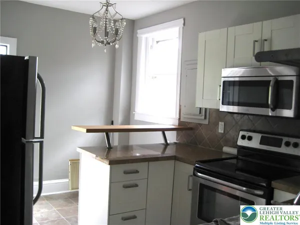 a kitchen with a refrigerator and a stove top oven