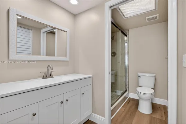 a bathroom with a granite countertop toilet sink and mirror