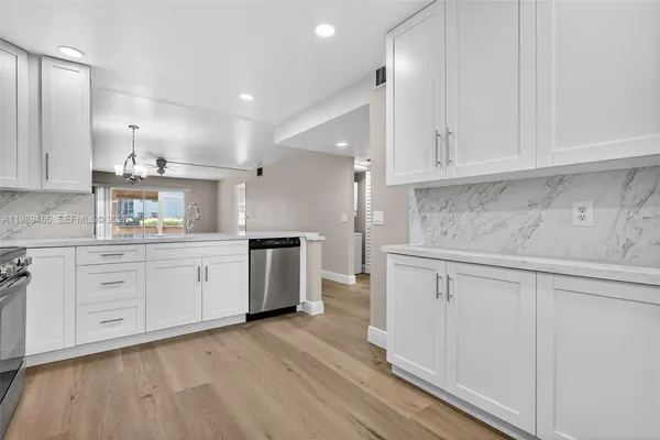 a kitchen with cabinets oven and a dishwasher with wooden floor