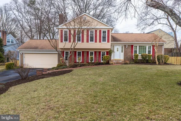 a front view of a house with a yard and trees