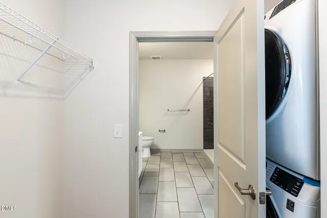 a view of a hallway with wooden floor and a bathroom