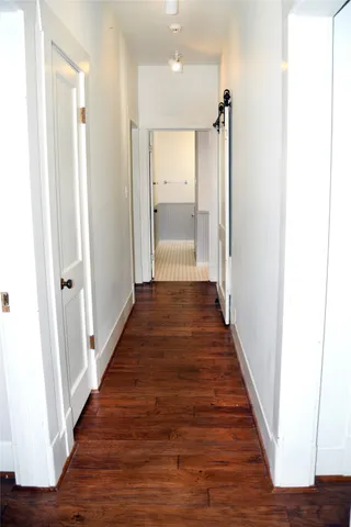 a view of a hallway with wooden floor