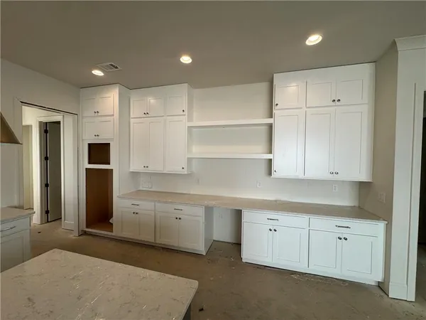a kitchen with white cabinets and refrigerator