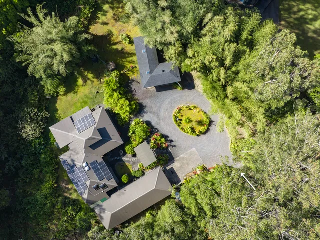 an aerial view of a house with garden space and street view