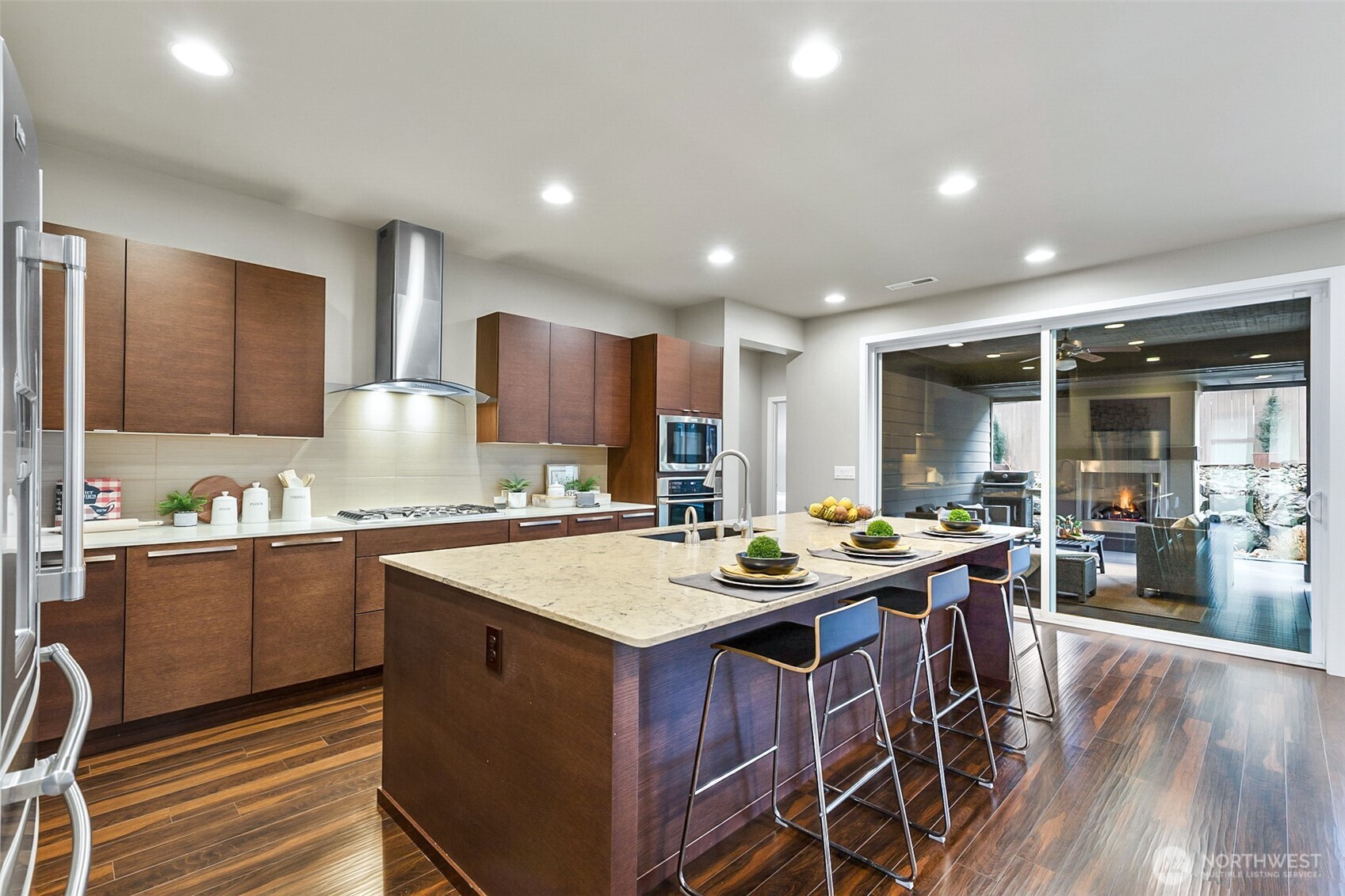 4009 168th Place Southeast Bothell, WA 98012 - Photo 11 of 38 a kitchen with stainless steel appliances granite countertop a stove a refrigerator a sink a dining table and chairs with wooden floor