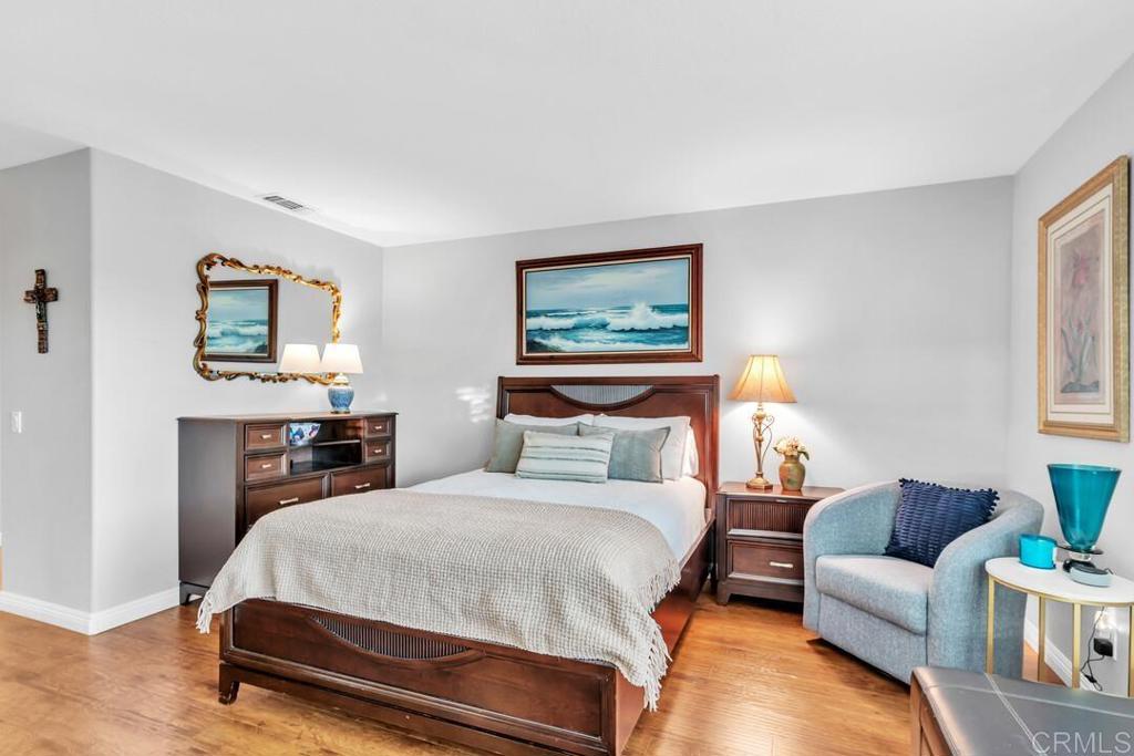 4169 Rhodes Way Oceanside, CA 92056 - Photo 26 of 42 a bedroom with a bed a couch and paintings on the wall
