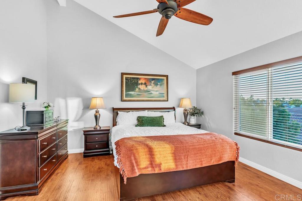 4169 Rhodes Way Oceanside, CA 92056 - Photo 29 of 42 a bedroom with a bed a chandelier and a flat tv screen