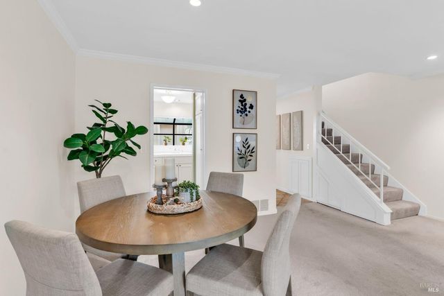 a kitchen with white cabinets and window