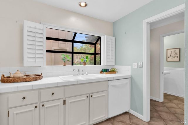 a kitchen with appliances a refrigerator a sink and cabinets
