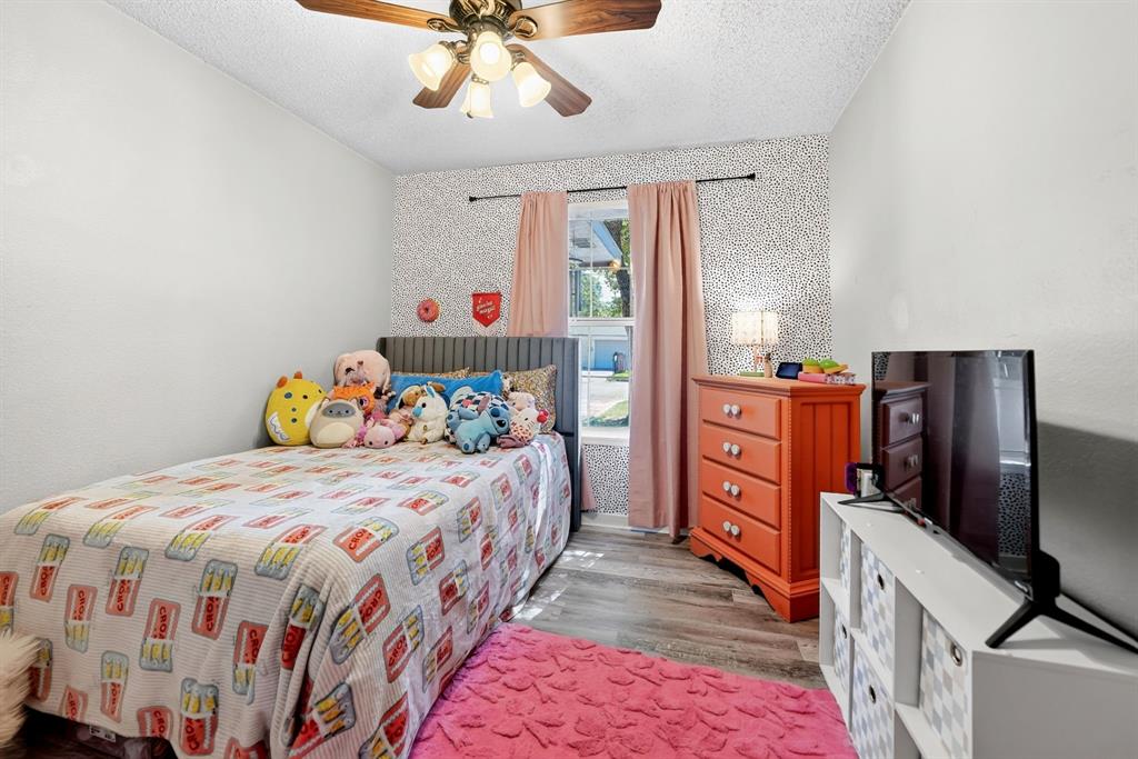 810 Edna Street Athens, TX 75751 - Photo 22 of 28 Room featuring wood-finish flooring, a window with natural light, and a ceiling fan with integrated lighting