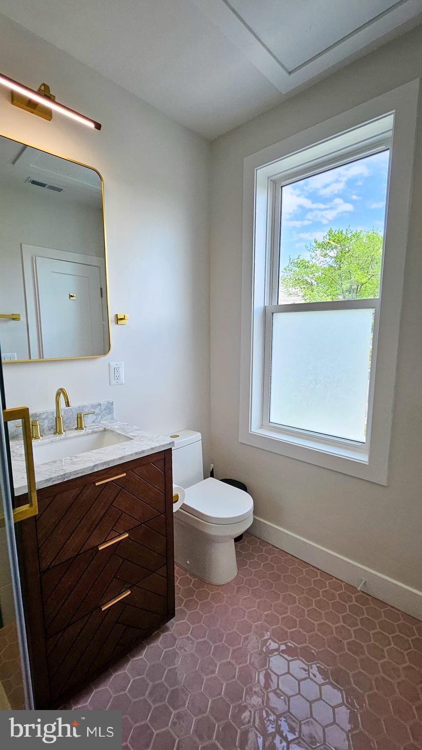 3206 Warder Street Northwest Washington, DC 20010 - Photo 23 of 30 a bathroom with a toilet a sink a vanity and mirror