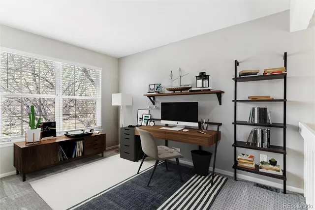 a view of a workspace with furniture and a window