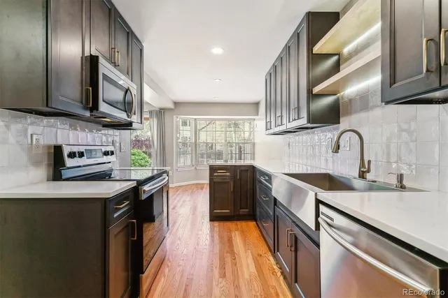 a kitchen with stainless steel appliances a sink stove and cabinets