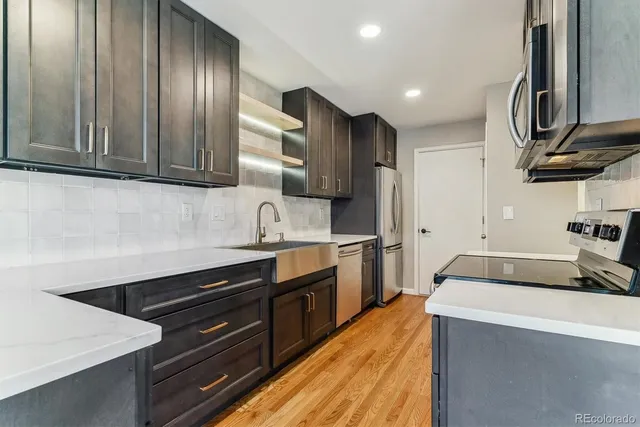 a kitchen with stainless steel appliances sink stove and cabinets