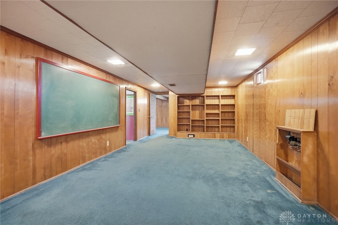 6119 Flemington Road Dayton, OH 45459 - Photo 40 of 76 This versatile room features warm wood paneling and built-in shelving, offering endless possibilities.