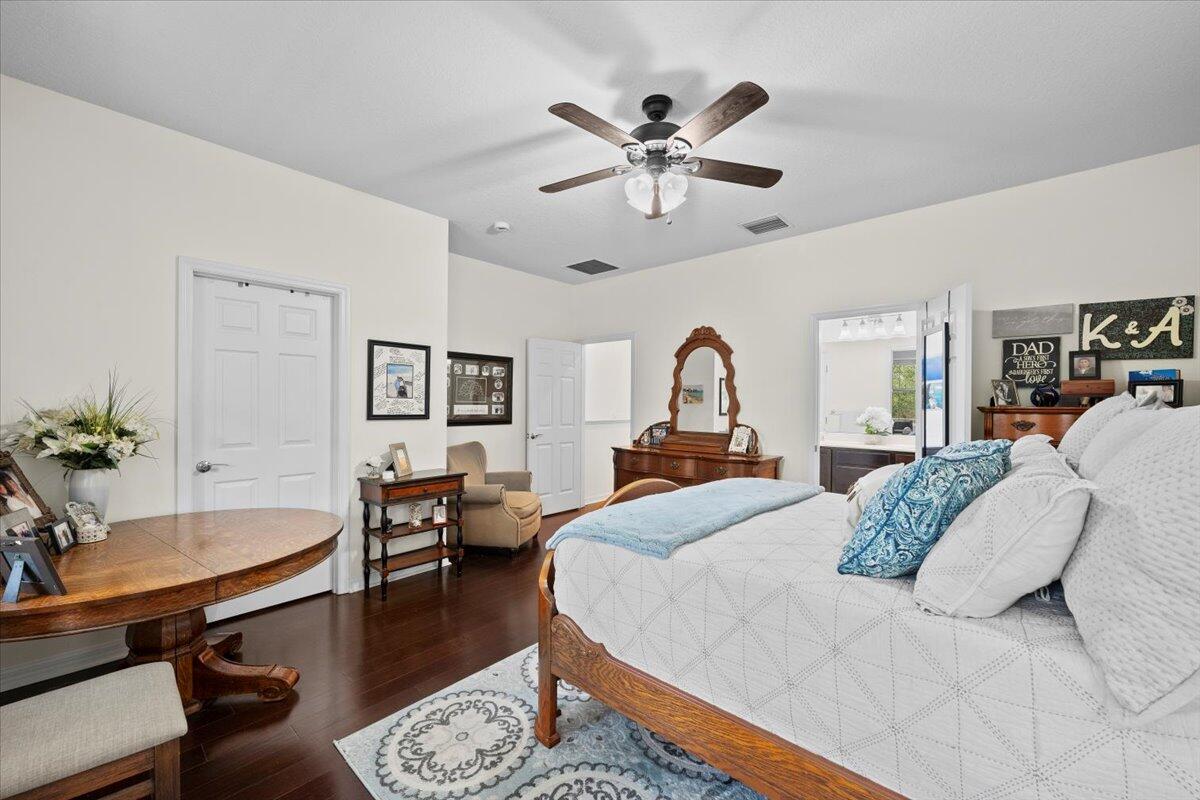 1108 South Community Drive Jupiter, FL 33458 - Photo 7 of 38 a bedroom with a large bed and a chandelier