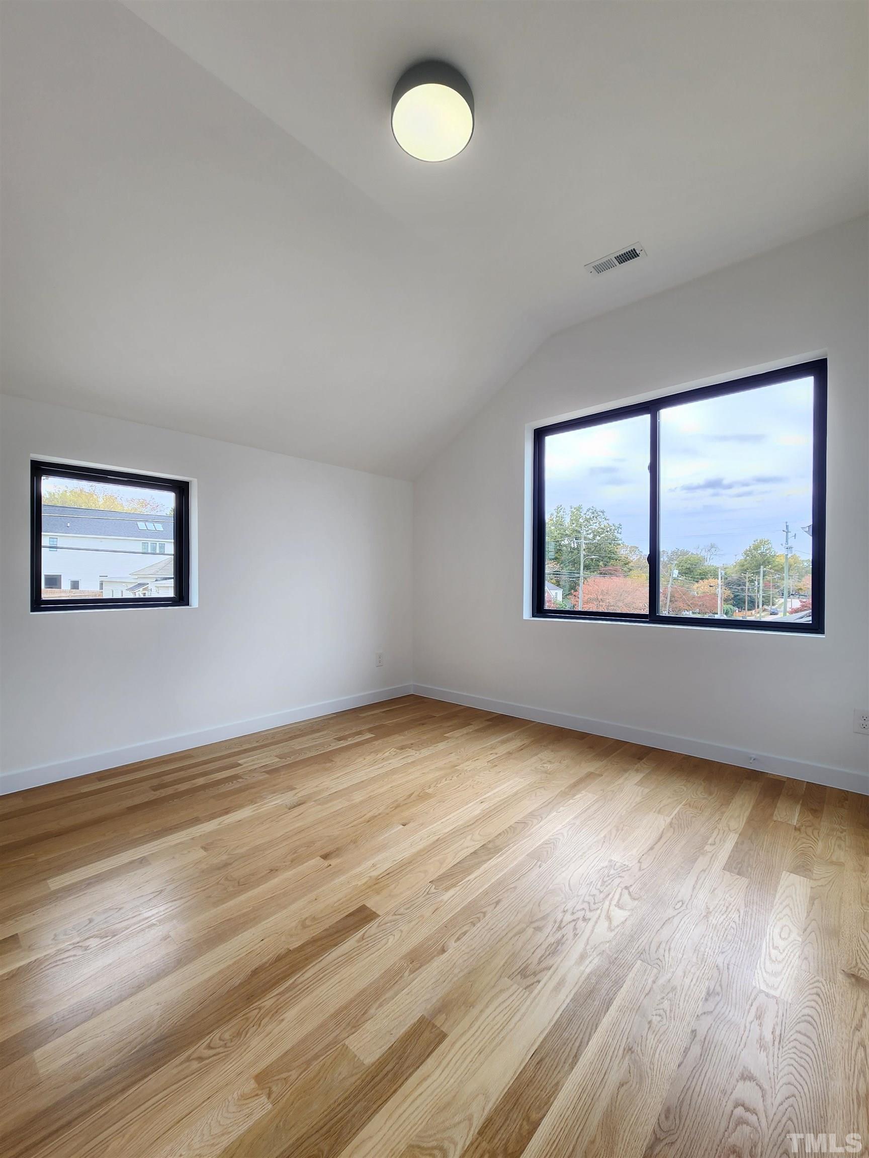 1203 East Lane Street Raleigh, NC 27601 - Photo 19 of 24 a view of an empty room with a window and wooden floor