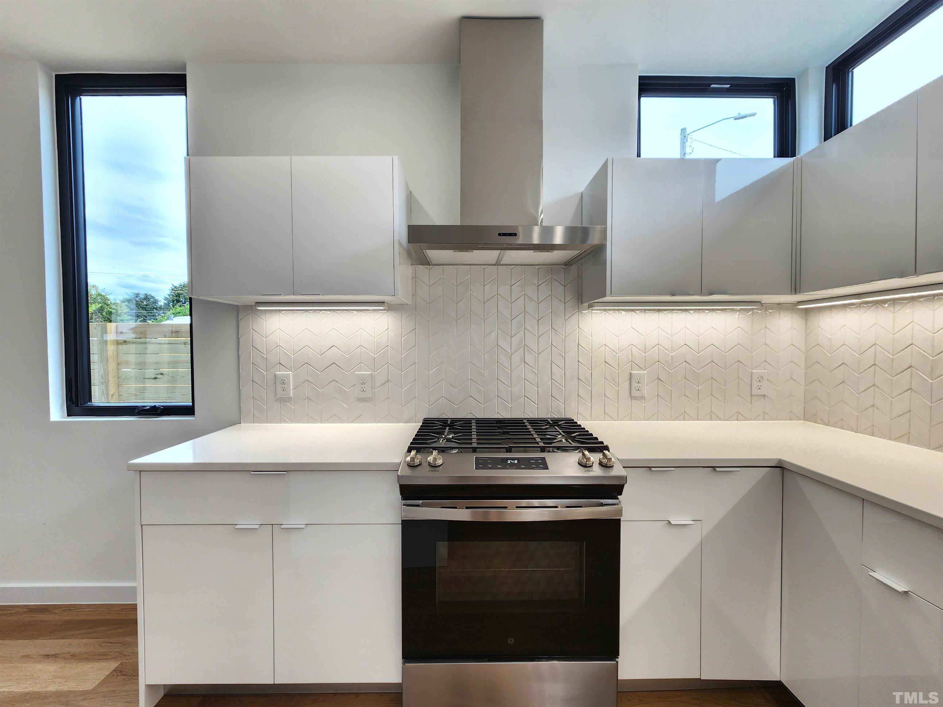 1203 East Lane Street Raleigh, NC 27601 - Photo 6 of 24 a kitchen with stainless steel appliances a stove a sink and a microwave