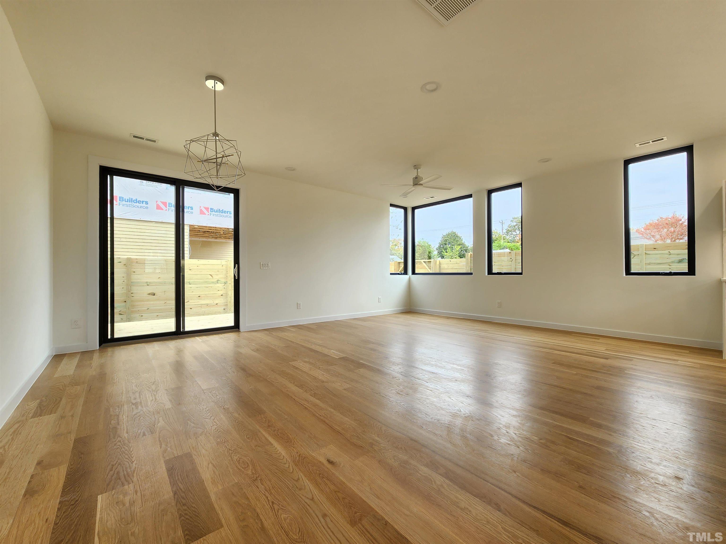 1203 East Lane Street Raleigh, NC 27601 - Photo 7 of 24 an empty room with wooden floor and windows