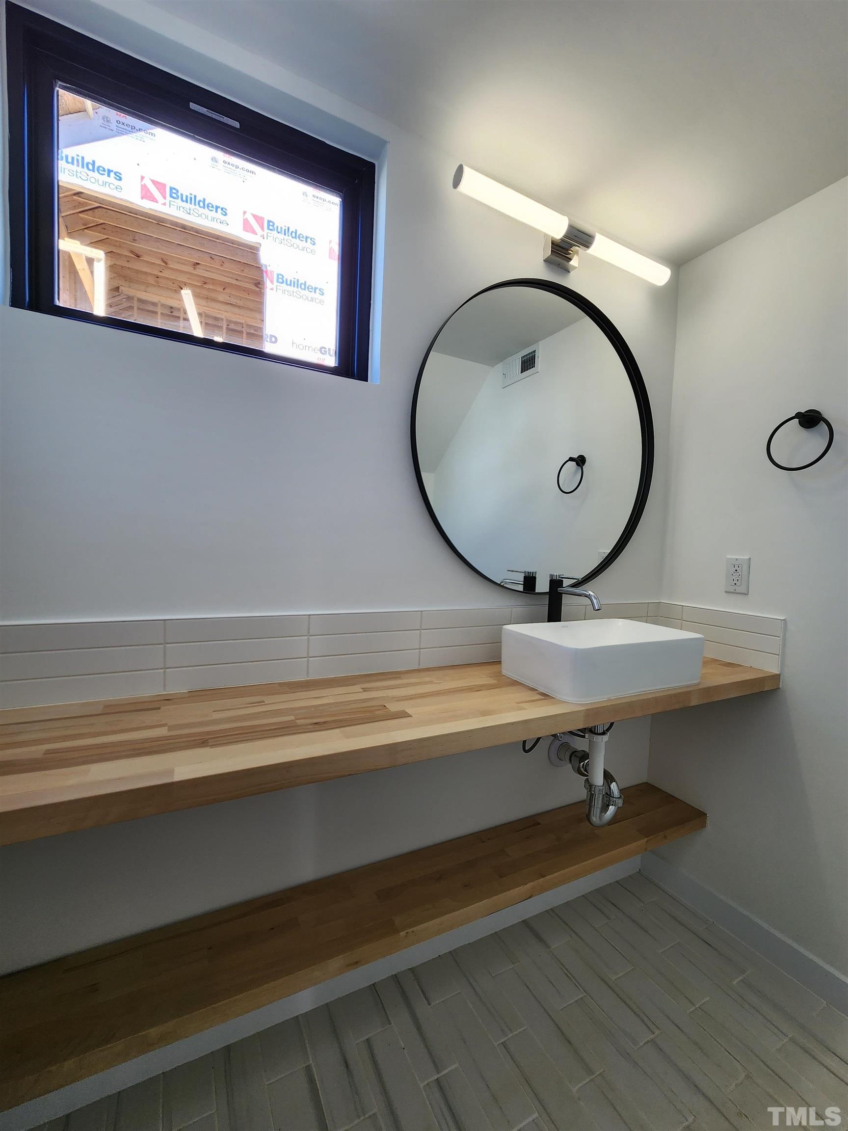 1203 East Lane Street Raleigh, NC 27601 - Photo 9 of 24 a bathroom with a sink a mirror and a shower