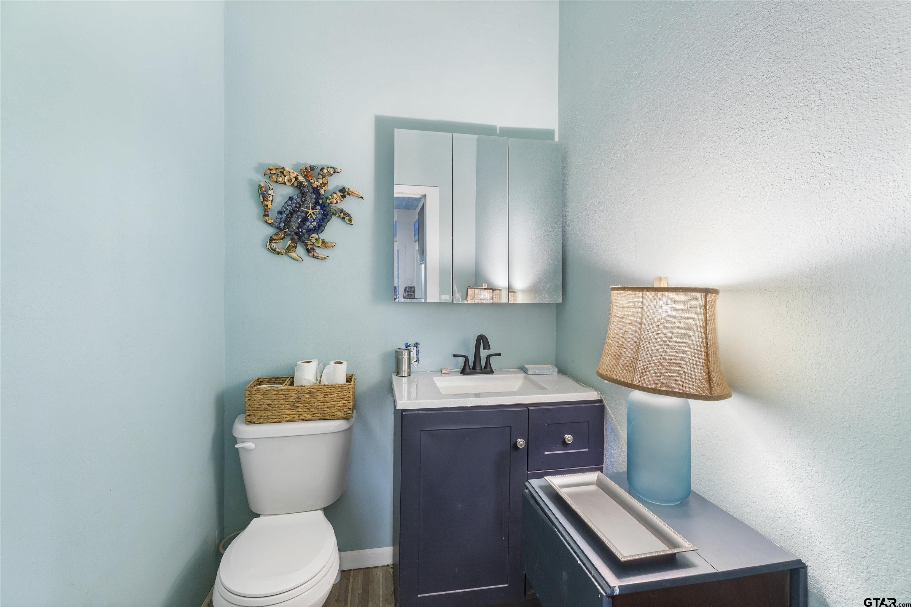 408 Morton Palacios, TX 77465 - Photo 14 of 29 a bathroom with a toilet sink and mirror