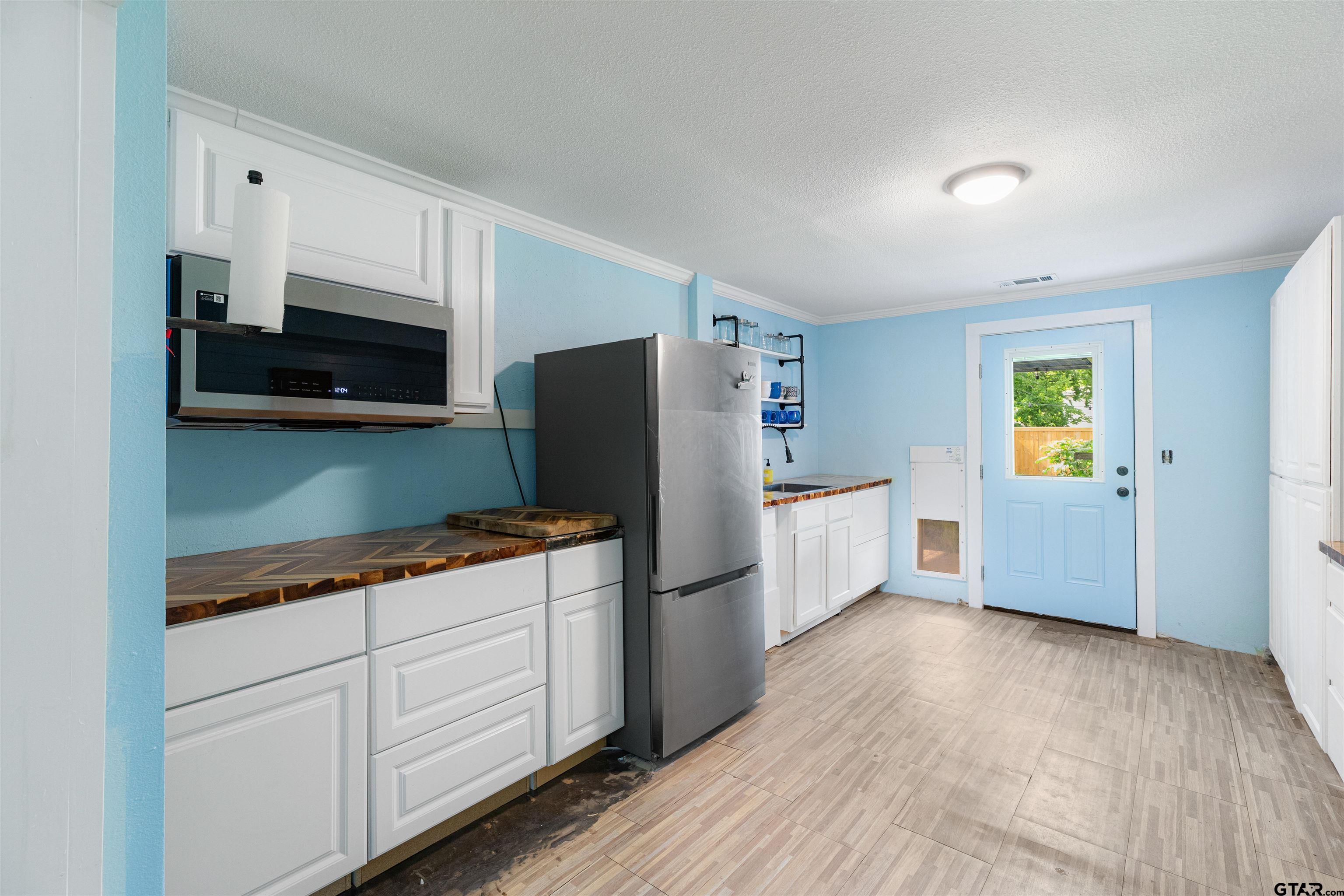 408 Morton Palacios, TX 77465 - Photo 10 of 29 a kitchen with a refrigerator cabinets and wooden floor