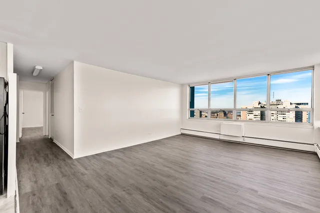a view of an empty room with wooden floor