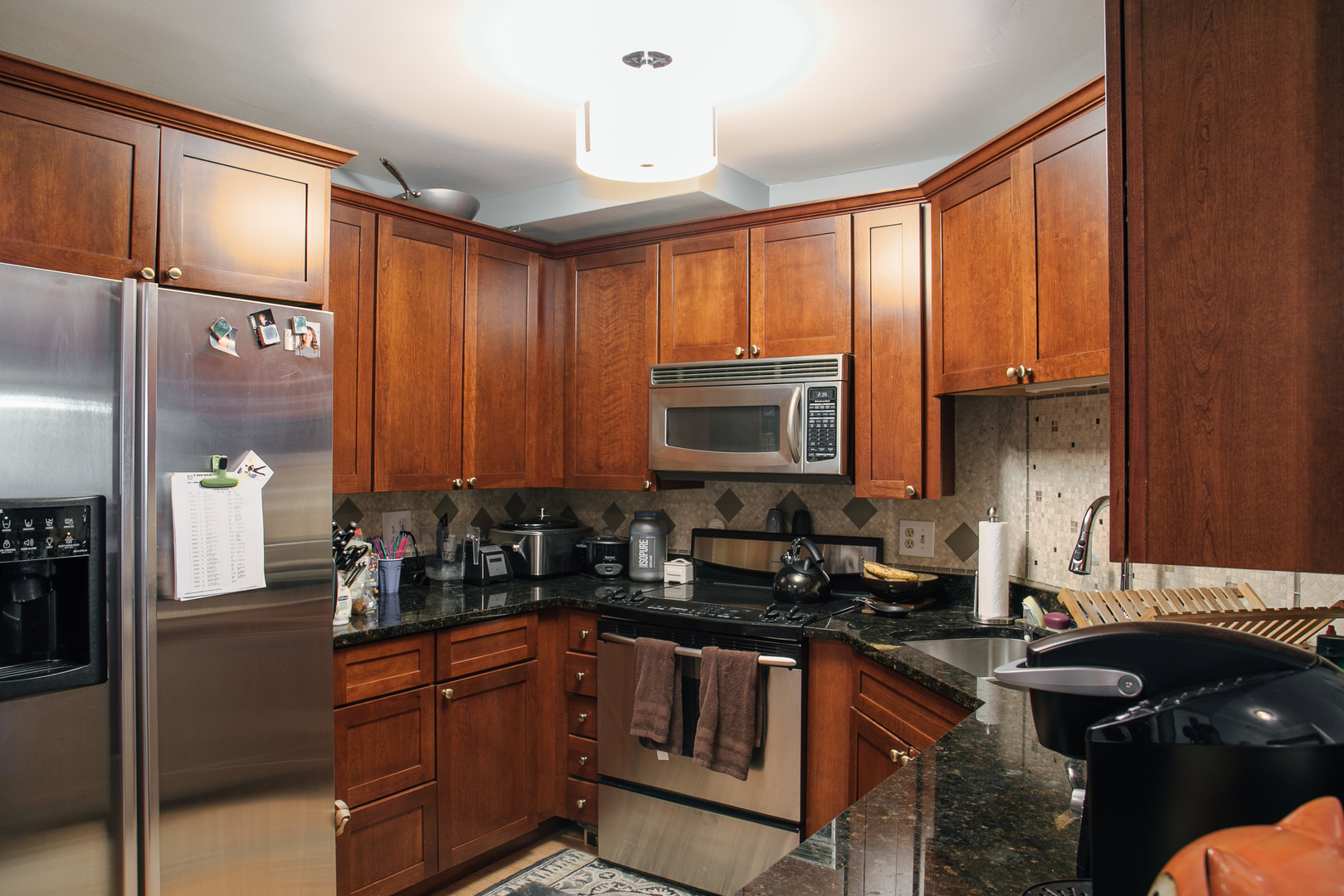195 North Harbor Drive, Unit 905 Chicago, IL 60601 - Photo 4 of 19 a kitchen with granite countertop a sink stove and cabinets