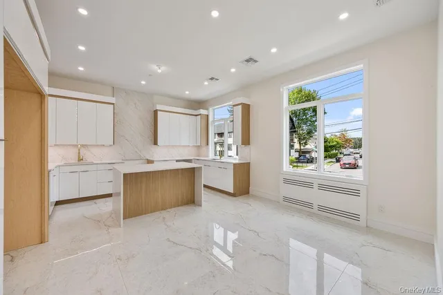 a view of a kitchen with a sink and dishwasher a refrigerator with white cabinets