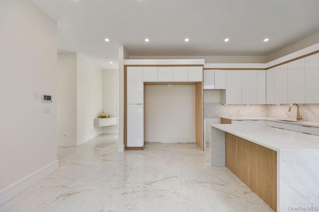 20 Singer Avenue, Unit 202 Spring Valley, NY 10977 - Photo 13 of 50 a view of a kitchen with a sink and dishwasher a refrigerator with white cabinets
