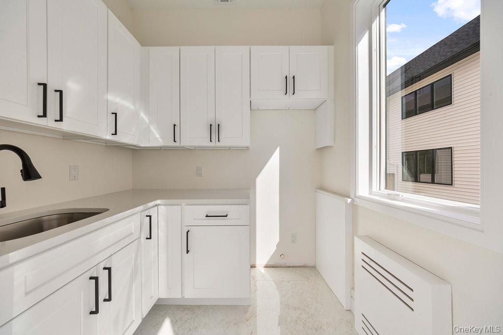 20 Singer Avenue, Unit 202 Spring Valley, NY 10977 - Photo 16 of 50 a kitchen with white cabinets and white appliances