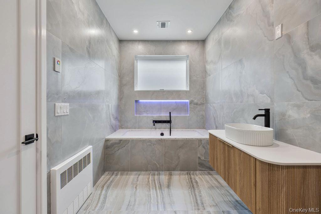 20 Singer Avenue, Unit 202 Spring Valley, NY 10977 - Photo 24 of 50 a bathroom with a sink a toilet a mirror and shower