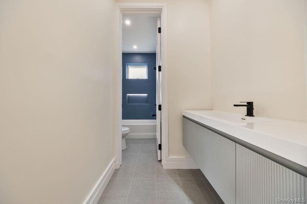 20 Singer Avenue, Unit 202 Spring Valley, NY 10977 - Photo 35 of 50 a bathroom with a sink and mirror with toilet