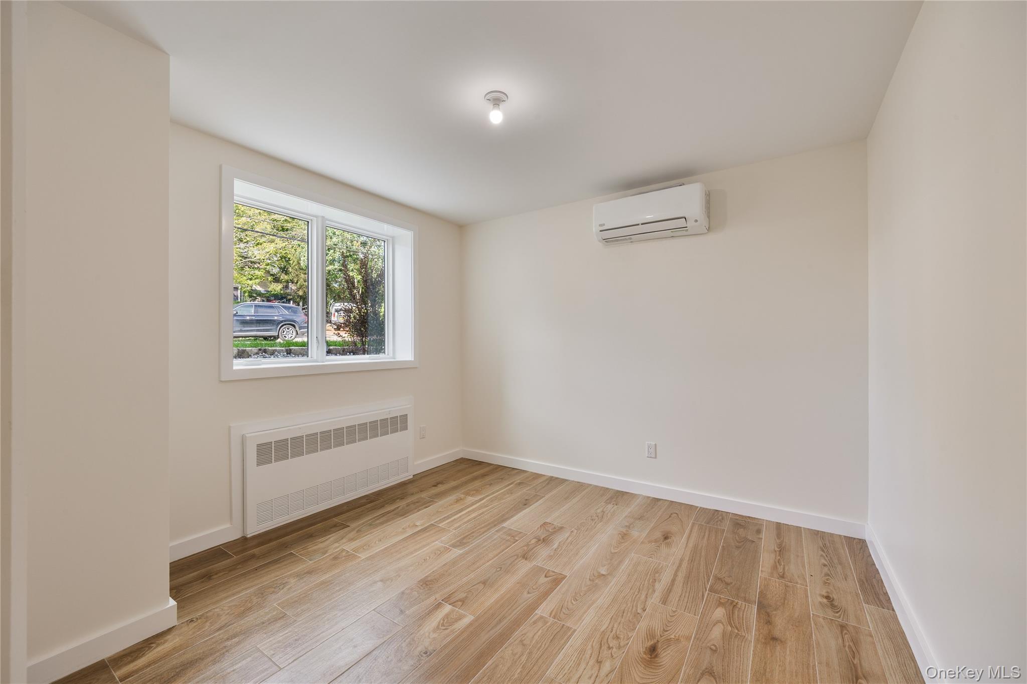 20 Singer Avenue, Unit 202 Spring Valley, NY 10977 - Photo 40 of 50 an empty room with wooden floor and windows
