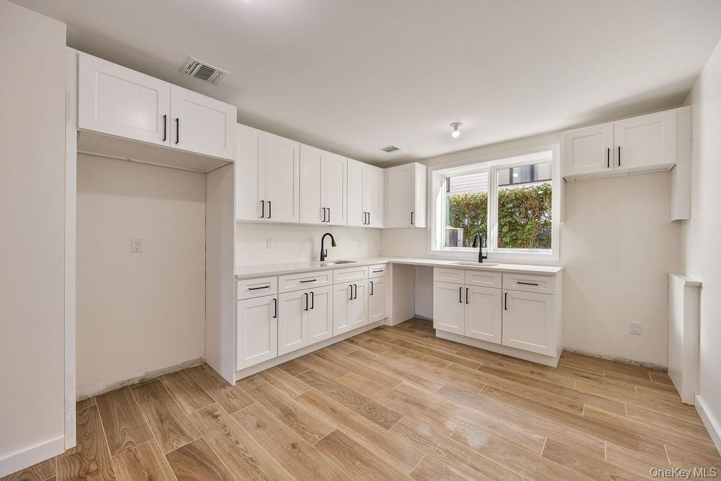 20 Singer Avenue, Unit 202 Spring Valley, NY 10977 - Photo 44 of 50 a kitchen with white cabinets and white appliances
