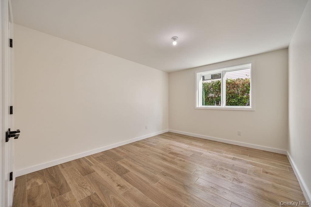 20 Singer Avenue, Unit 202 Spring Valley, NY 10977 - Photo 45 of 50 an empty room with wooden floor and windows