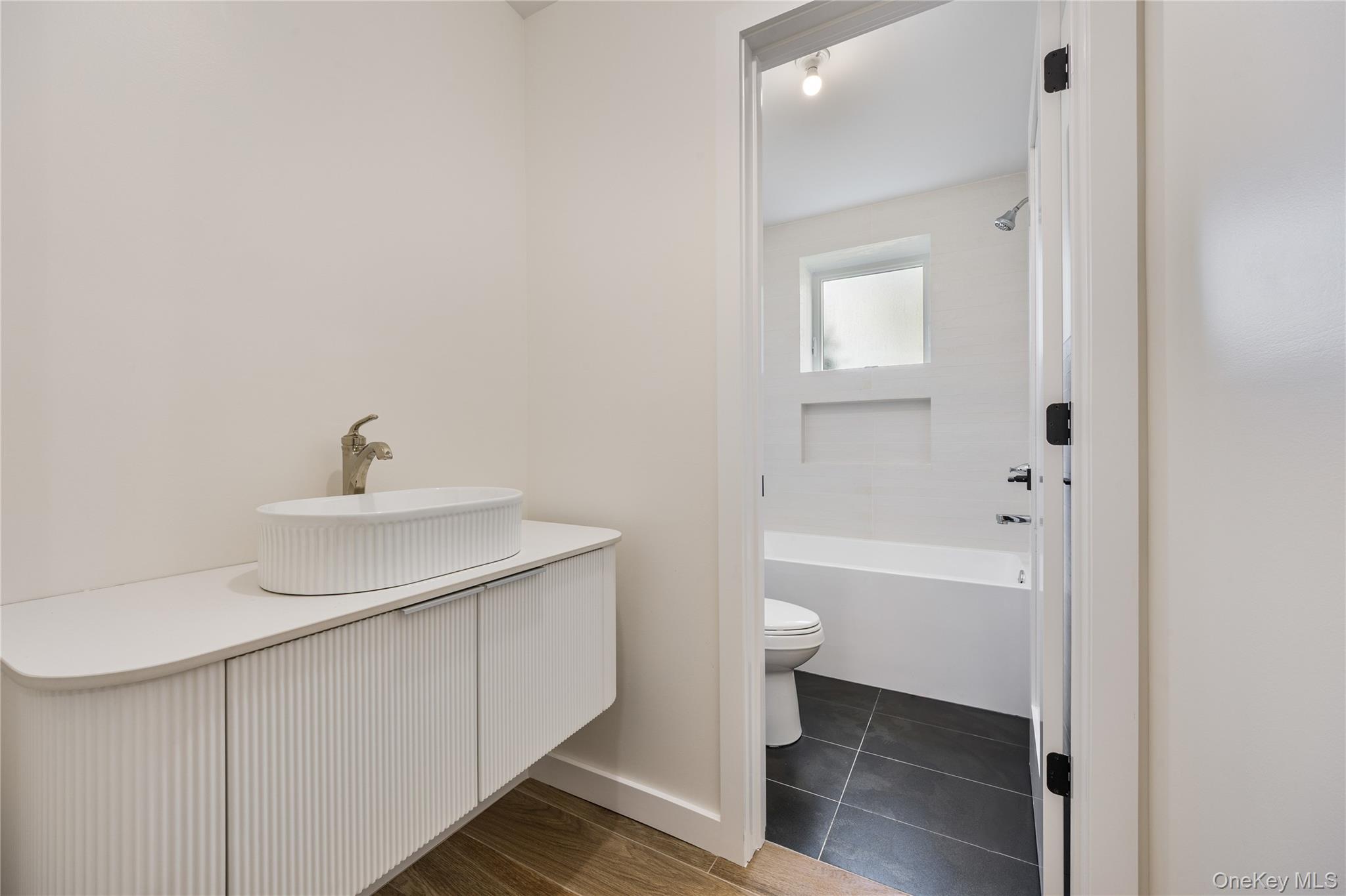 20 Singer Avenue, Unit 202 Spring Valley, NY 10977 - Photo 48 of 50 a bathroom with a sink a toilet and shower