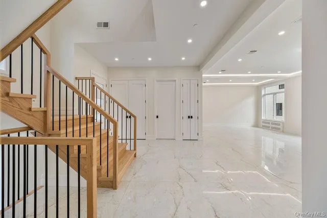 a view of a hallway with wooden floor and staircase