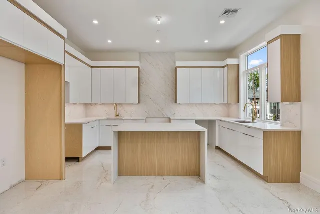 a large kitchen with kitchen island granite countertop a large window