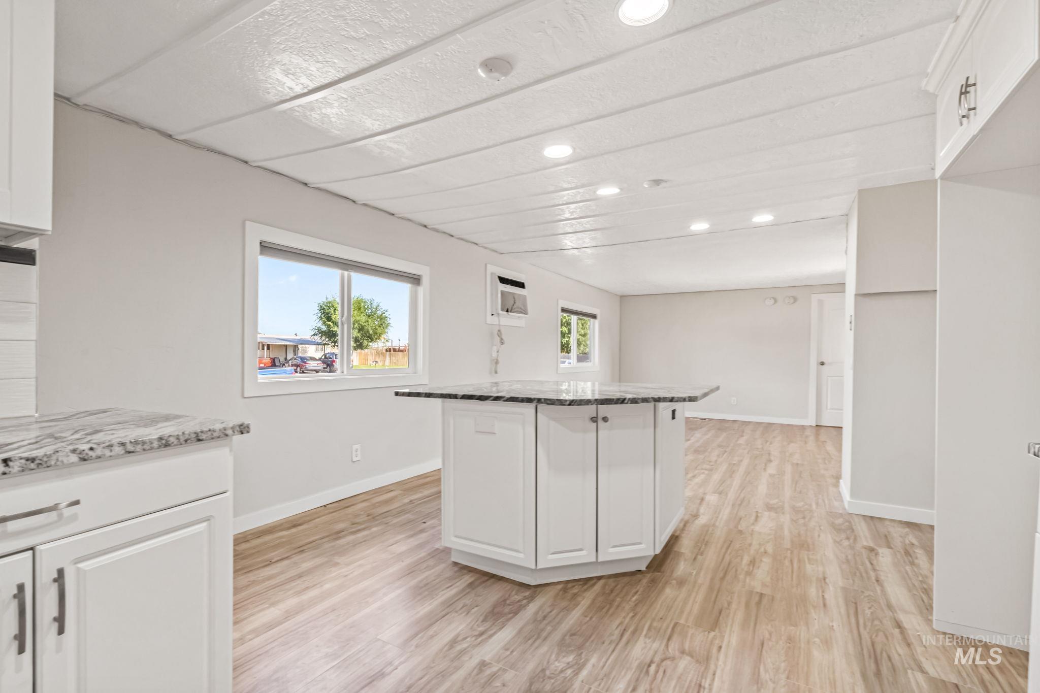 5015 East Ustick Road, Unit 181 Caldwell, ID 83605 - Photo 15 of 28 Kitchen with white cabinets, recessed lighting, light wood-style floors, light stone counters, and a center island