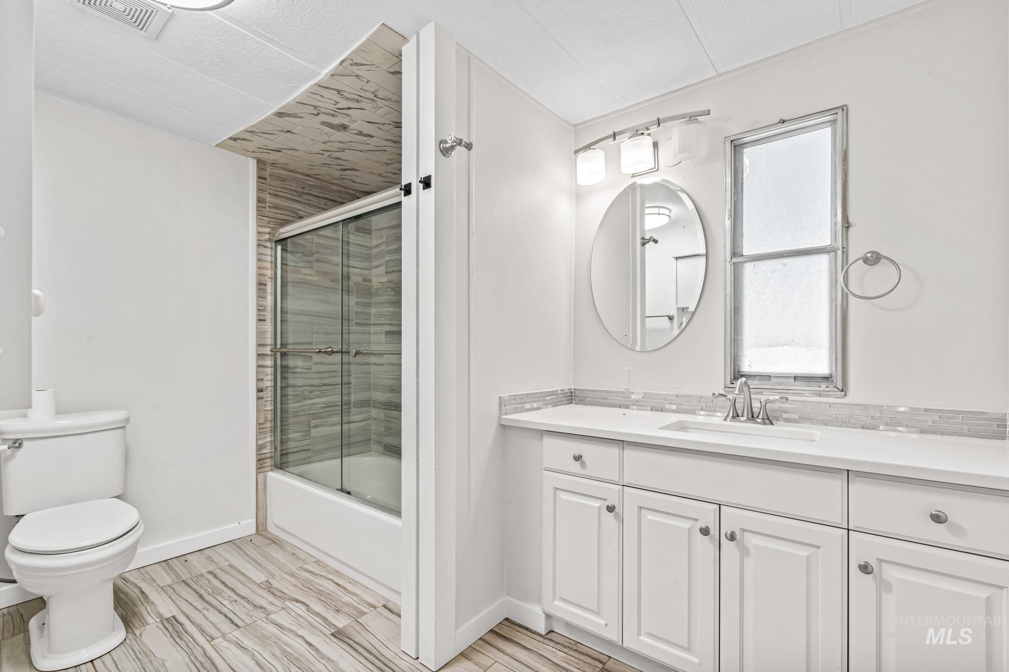 5015 East Ustick Road, Unit 181 Caldwell, ID 83605 - Photo 17 of 28 Full bathroom with bath / shower combo with glass door, vanity, and wood finish floors