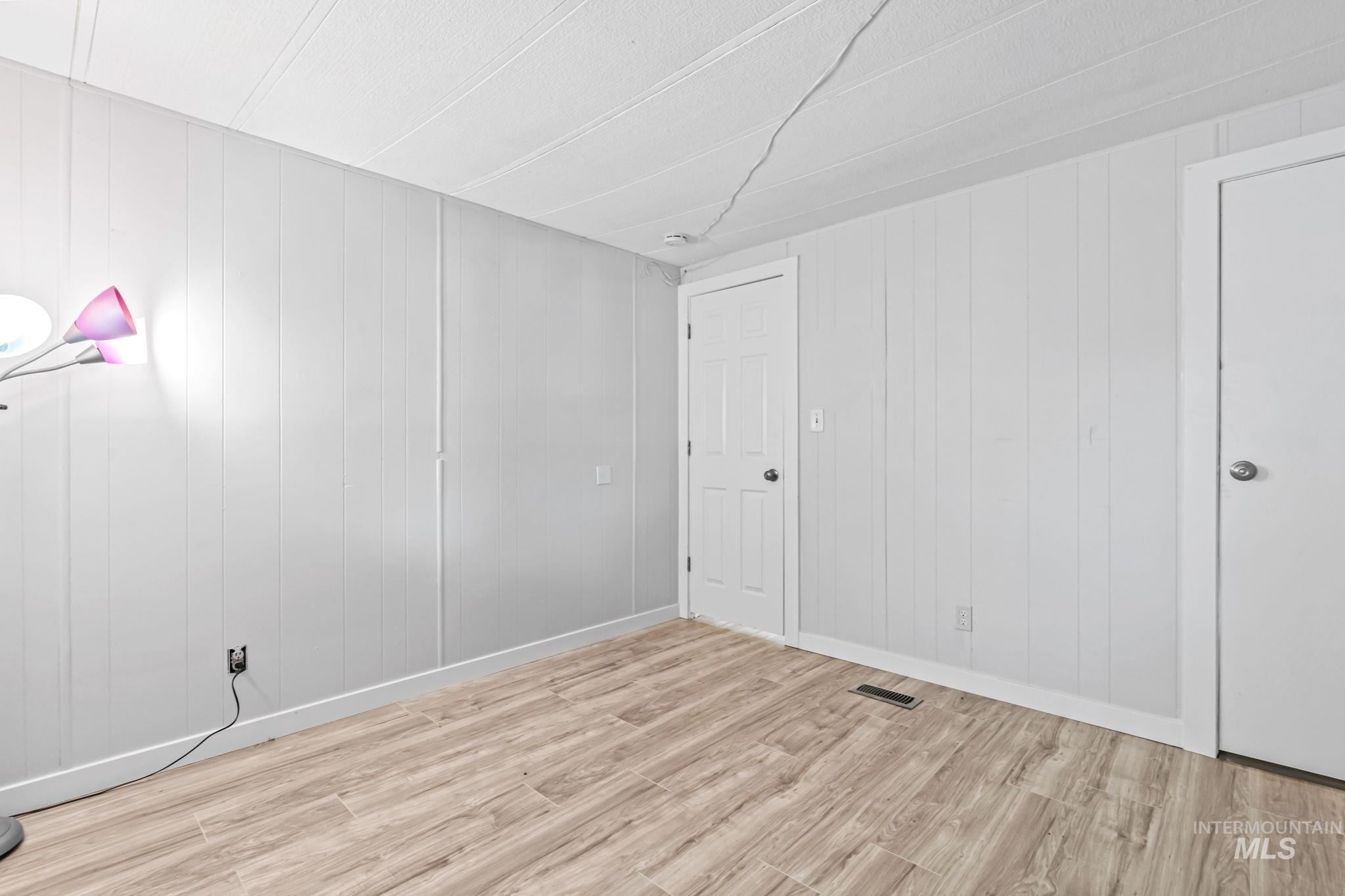 5015 East Ustick Road, Unit 181 Caldwell, ID 83605 - Photo 19 of 28 Unfurnished room with light wood finished floors and wood walls