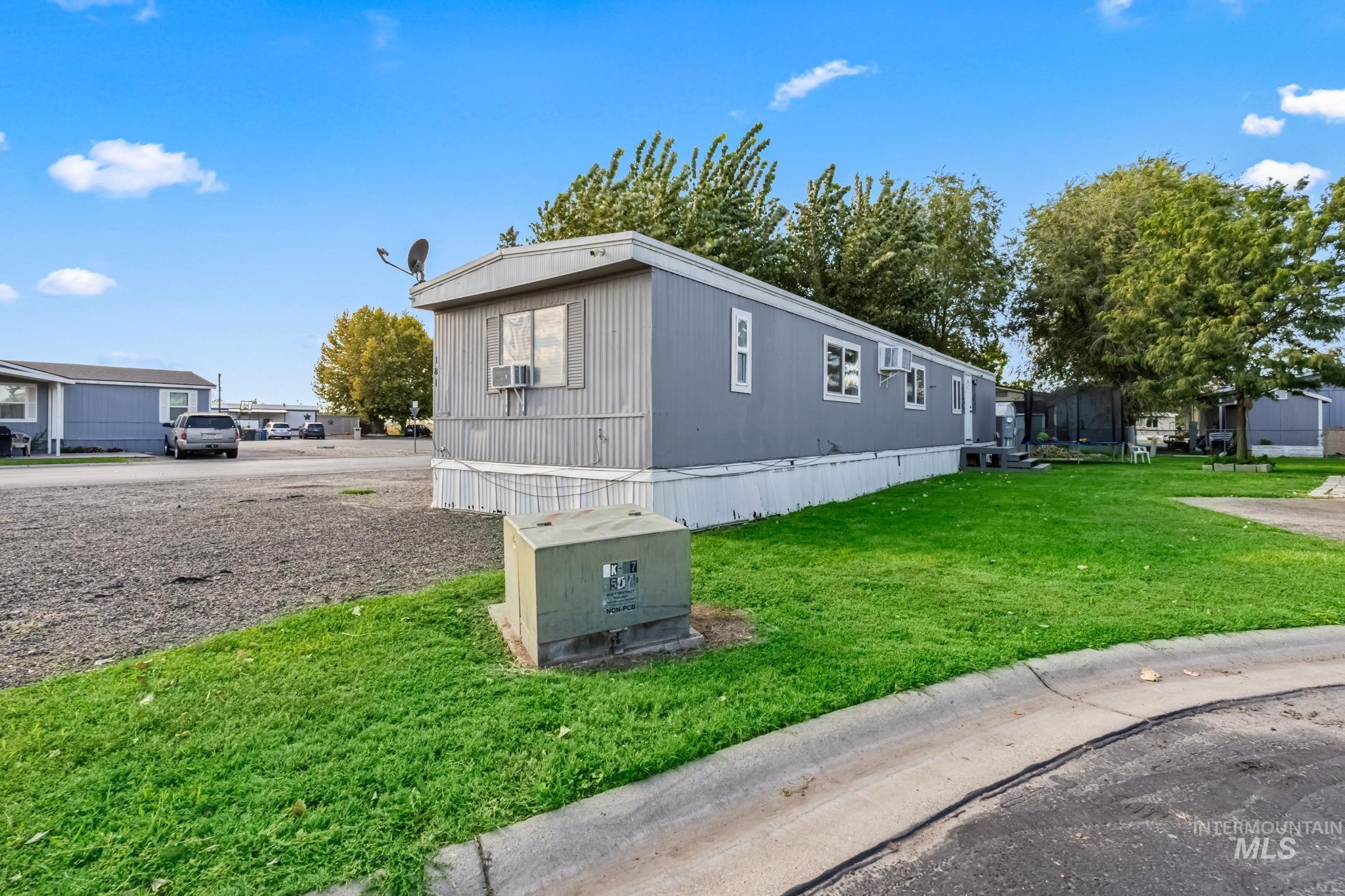 5015 East Ustick Road, Unit 181 Caldwell, ID 83605 - Photo 21 of 28 View of property exterior featuring a lawn and a trampoline