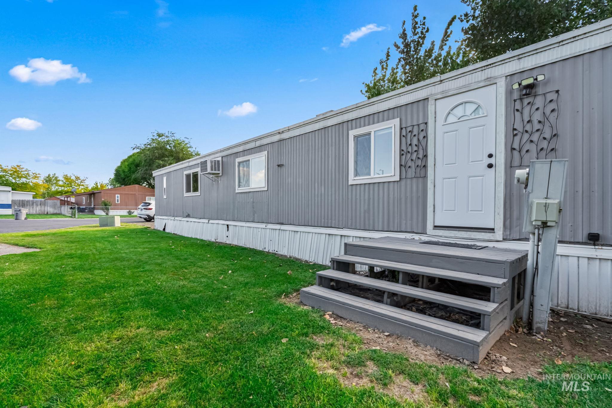 5015 East Ustick Road, Unit 181 Caldwell, ID 83605 - Photo 22 of 28 Rear view of house featuring a lawn