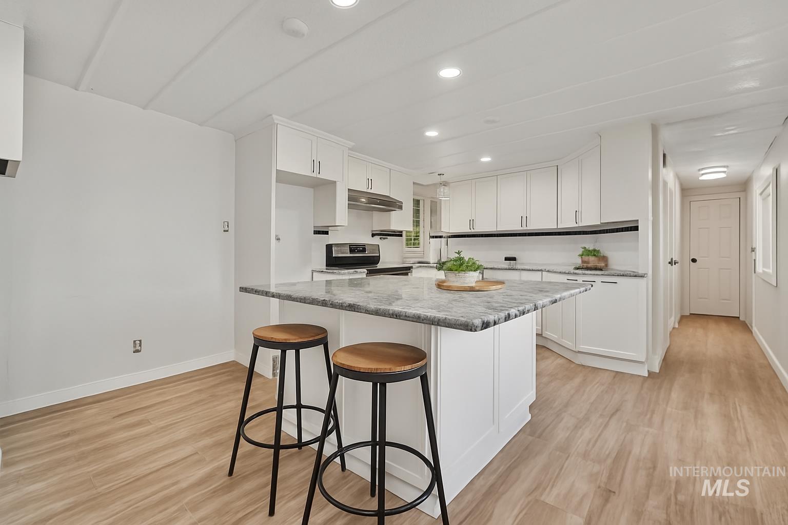 5015 East Ustick Road, Unit 181 Caldwell, ID 83605 - Photo 7 of 28 Kitchen with white cabinets, light wood-style flooring, a breakfast bar, recessed lighting, and a center island