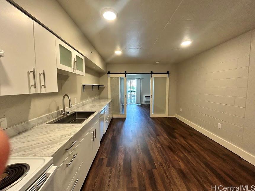 803 Waimanu Street, Unit 401 Honolulu, HI 96813 - Photo 2 of 18 a kitchen with granite countertop a sink and wooden floor