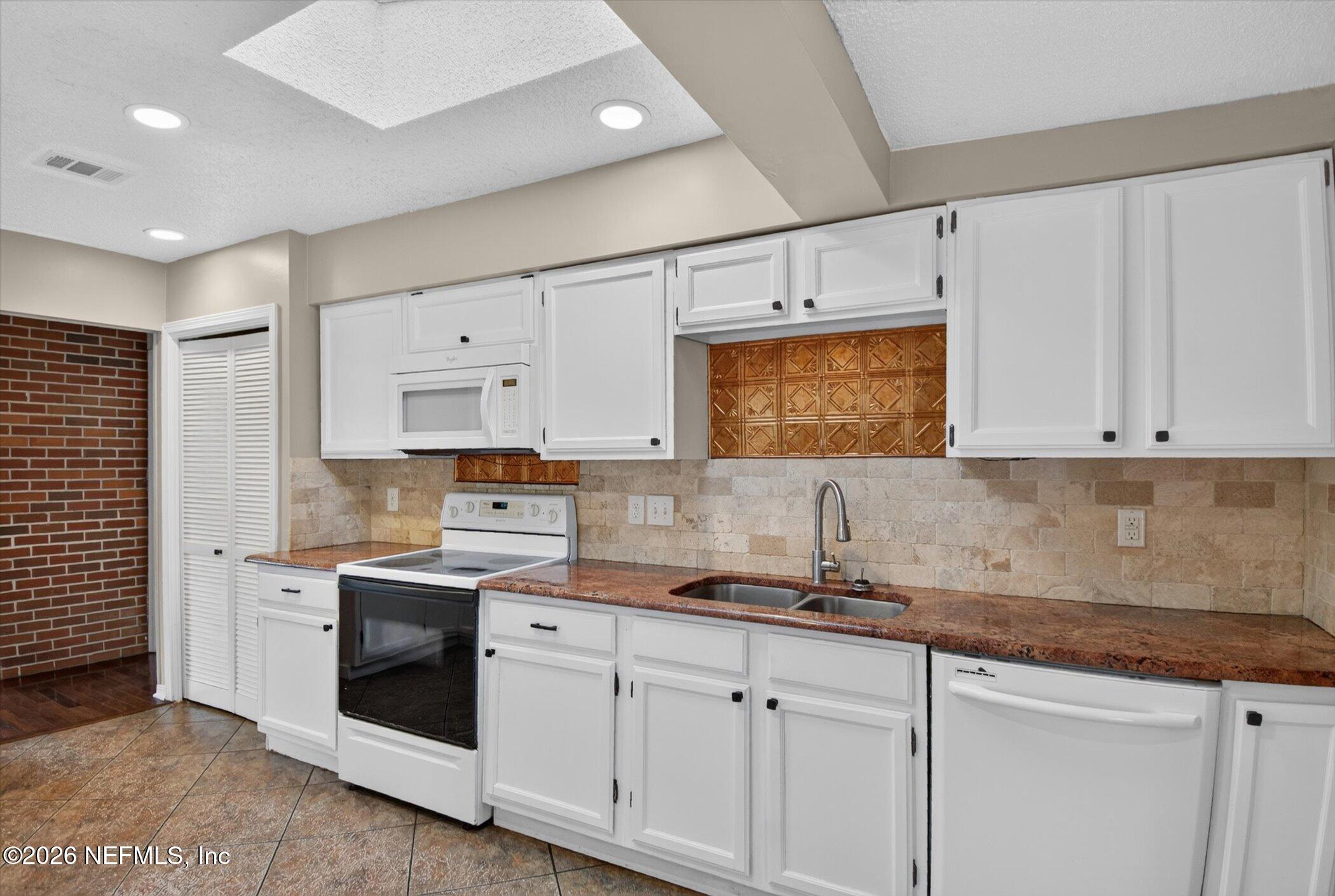 2705 Navajo Road Orange Park, FL 32073 - Photo 27 of 58 a kitchen with granite countertop white cabinets and white appliances