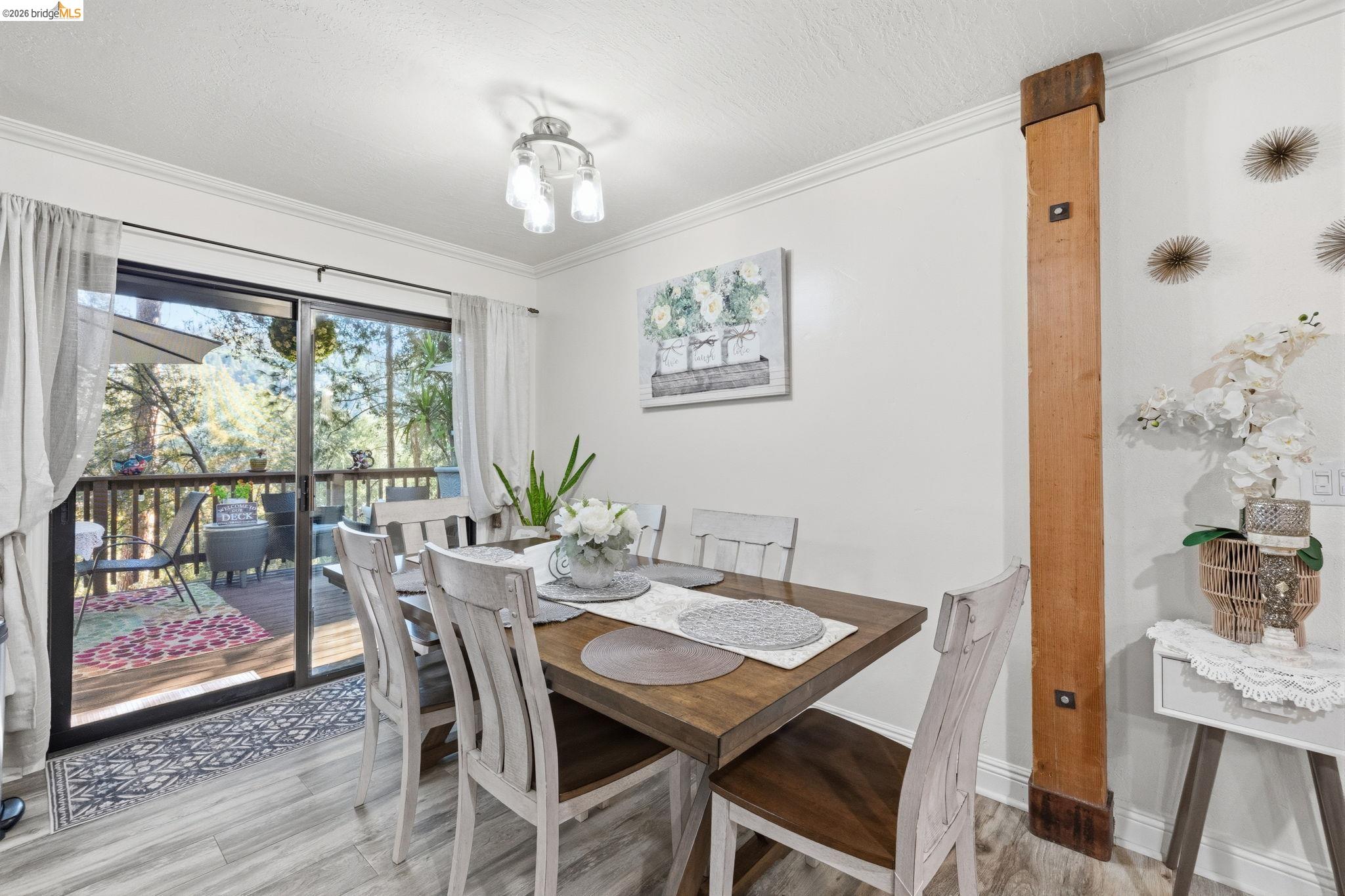 21999 Fallview Drive Sonora, CA 95370 - Photo 14 of 36 Dining room featuring ornamental molding, light wood-style flooring, a textured ceiling, and suspended lighting