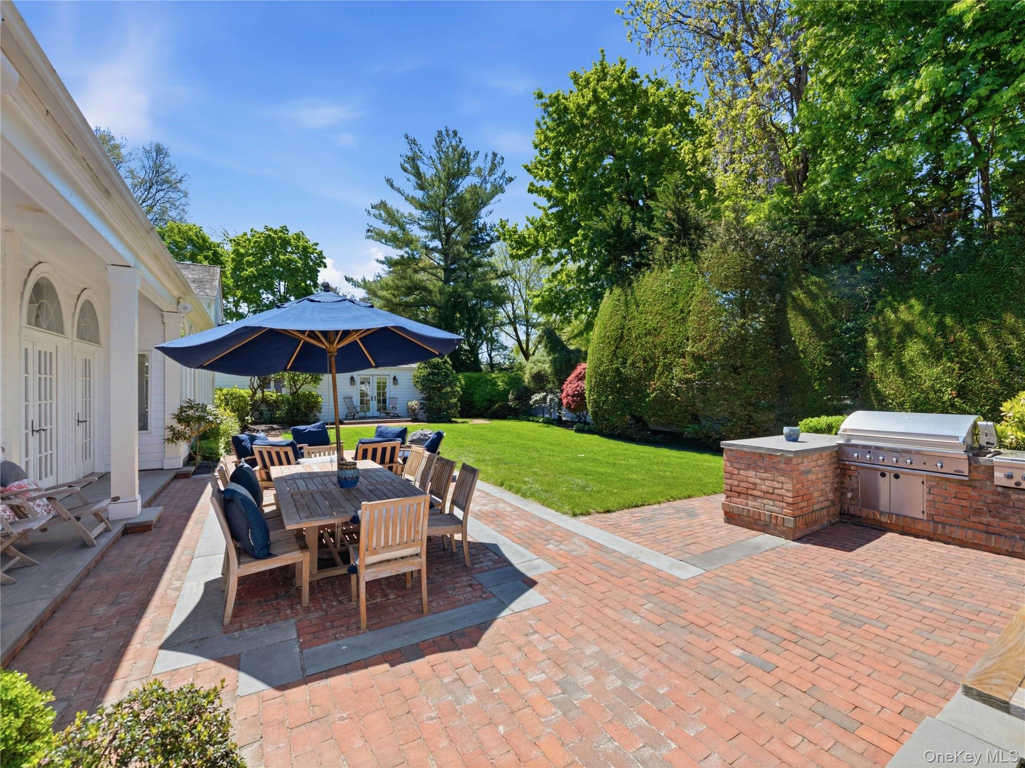 2 Aspen Place Great Neck, NY 11021 - Photo 35 of 48 Brick patio with outdoor kitchen, dining area, and lush yard.