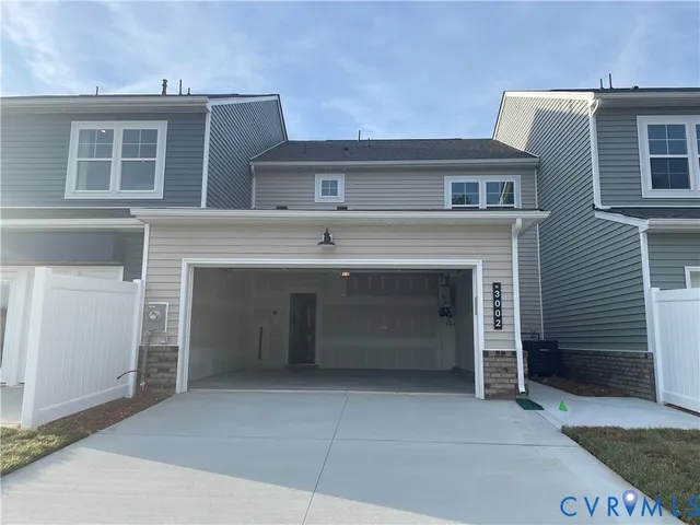 a front view of a house with a garage and a yard